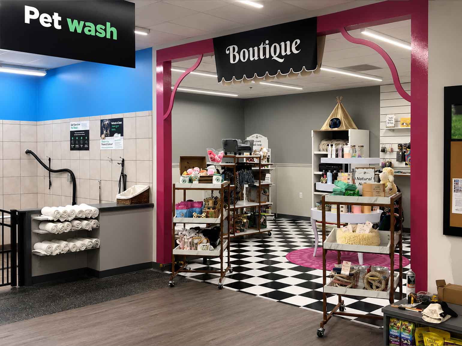 Pet wash station and pet boutique with grooming supplies, toys, and accessories in a modern retail store.