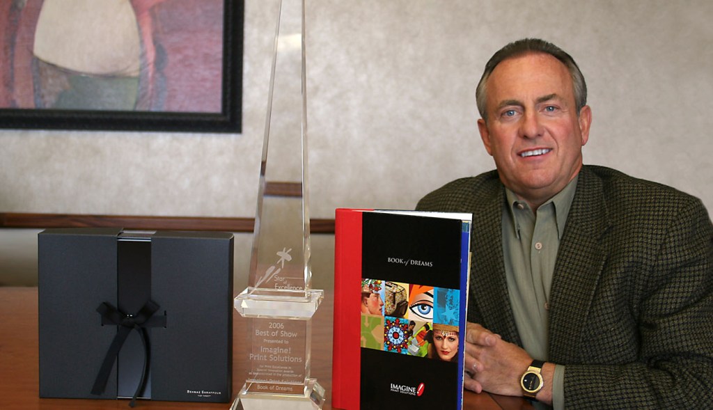 Businessman posing with books and awards