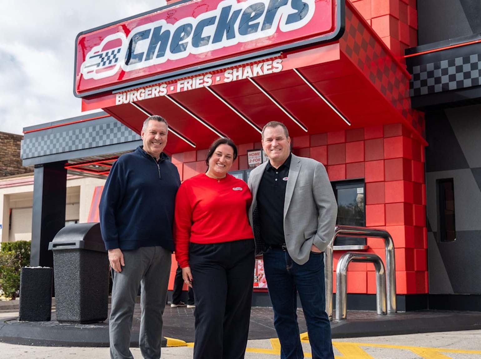 Employees smiling in front of restaurant